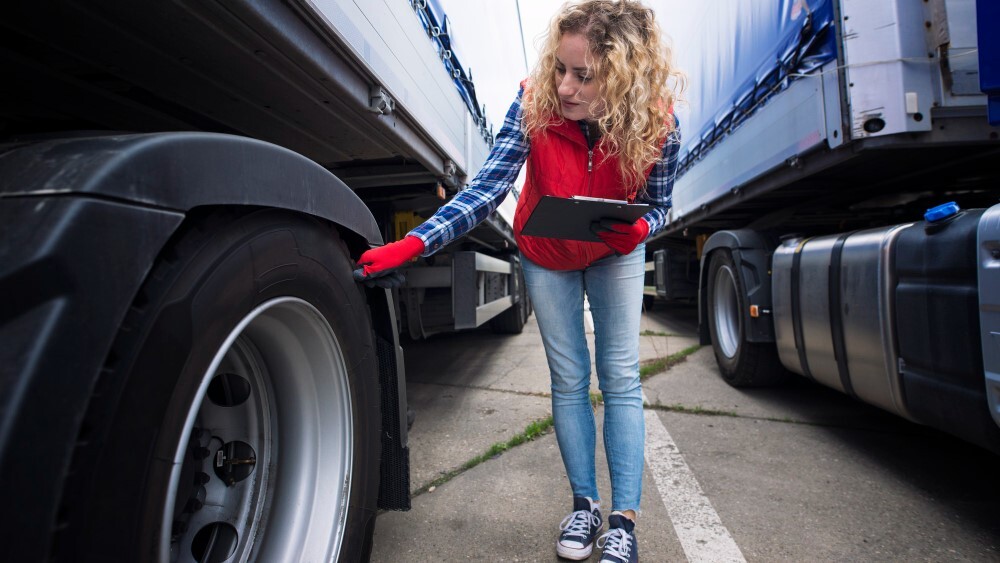 Truck driver checking vehicle tires and inspecting truck before ride