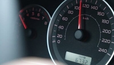 Close-up of a car speedometer showing a high speed in kilometers per hour, representing driver behavior monitoring and telematics data tracking for fleet safety.