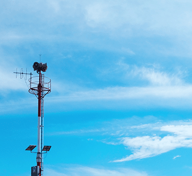 Telecommunication tower with antennas and solar panels against a blue sky, representing network upgrades and 3G to 4G IoT connectivity transition.