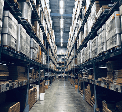 Large warehouse with tall storage racks filled with tools, equipment, and materials, representing tool tracking, inventory management, and asset monitoring solutions.