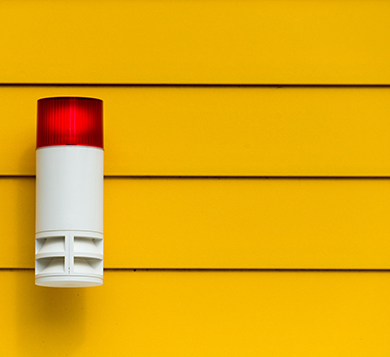 Red and white alarm on yellow wall
