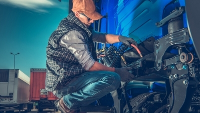 Photo of a man doing maintenance on a large truck